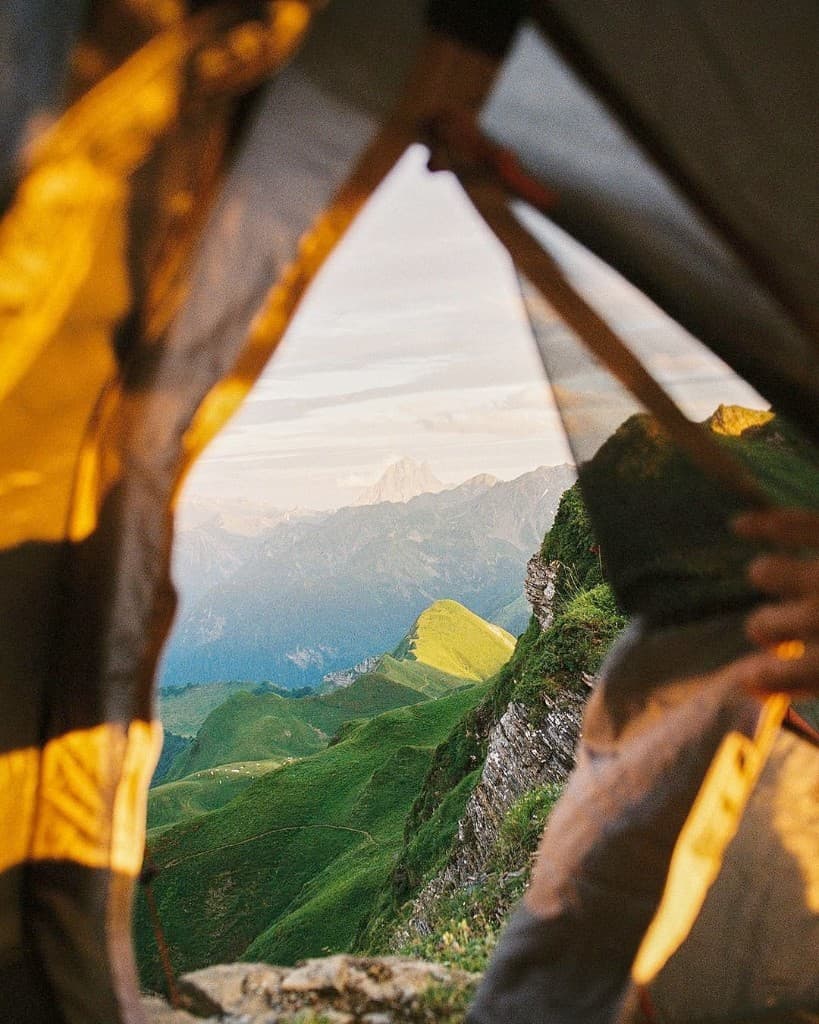 Une tente face aux montagnes au lever du soleil